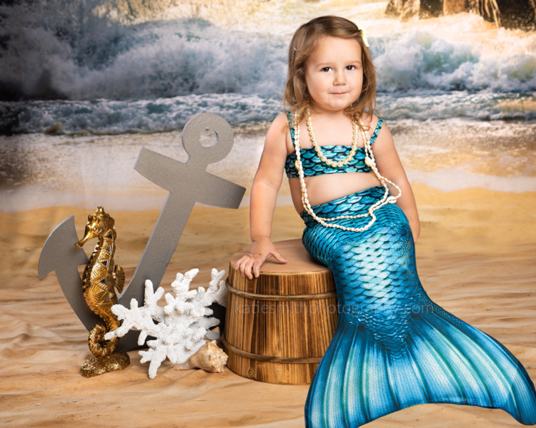 In studio portrait of a little girl wearing a mermaid costume