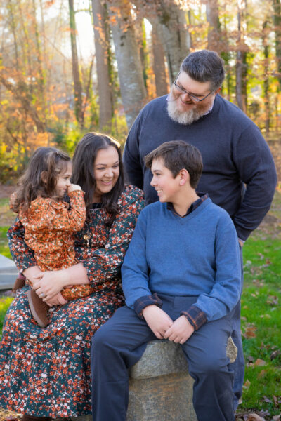 A family laughing together to illustrate the need to share stories and jokes during their session.