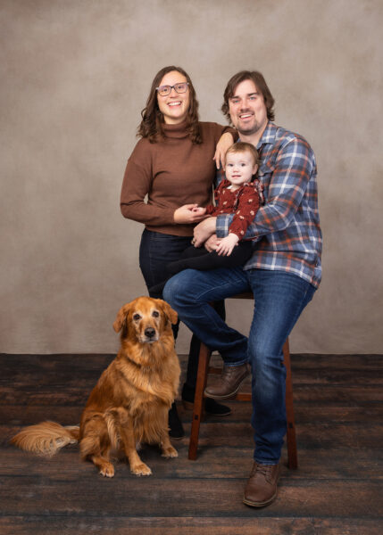 A studio family portrait of two parents, a toddler, and a golden retriever to encourage people to bring their dog to their next photo session.