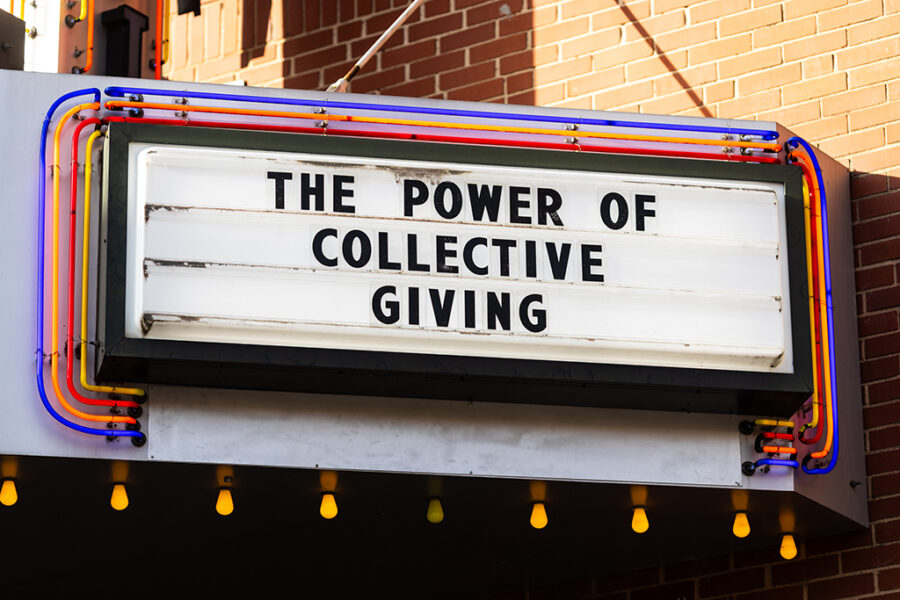 Photograph of a marque featuring the words "The Power of Collective Giving" outside a non-profit organization meeting.