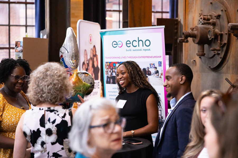 Event photography image featuring several individuals networking and mingling prior to a meeting.