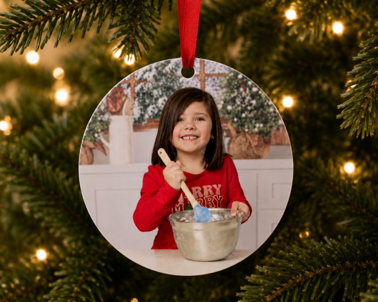 Christmas ornament featuring a portrait of a girl in Christmas attire stirring cookies